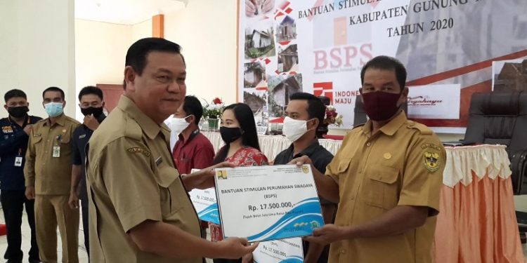 Sekda Gumas Yansiterson (kiri) menyerahkan bantuan secara simbolis, saat sosialisasi pelaksanaan kegiatan BSPS di Kuala Kurun, Senin (31/8/2020).