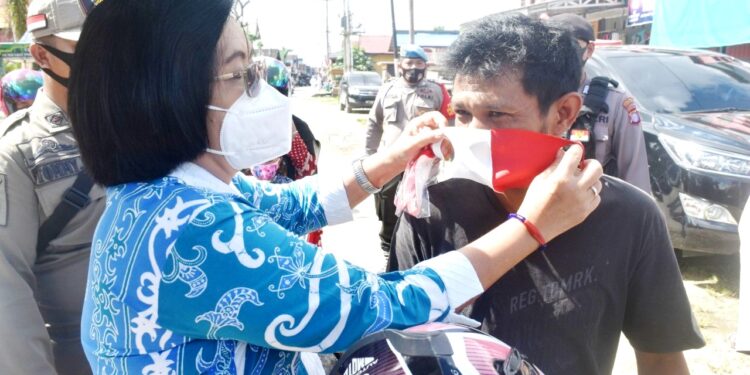 Wabup Gumas Efrensia LP Umbing ketika turut membagikan masker kepada pelintas jalan raya di area Taman Kota Kuala Kurun, Kamis (10/9/2020) (Foto:IST)