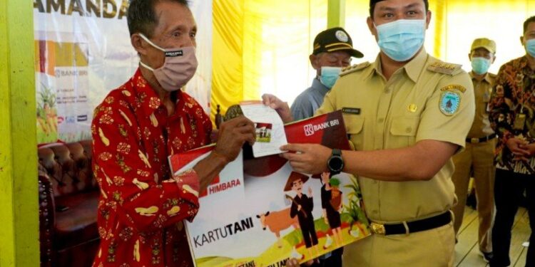 Bupati Lamandau, Hendra Lesmana (kanan) saat menyerahkan Kartu Tani di wilayah setempat, Selasa, (29/9/2020). (ANT/IST)