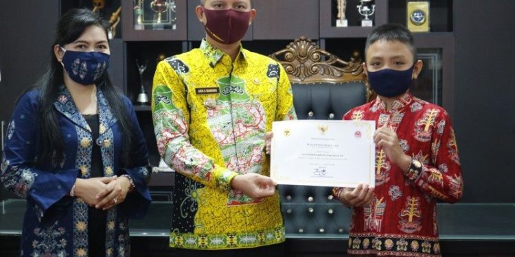 Bupati Gumas Jaya S Monong (tengah) didampingi Ketua Dekranasda Kabupaten Gumas Mimie Mariatie Jaya S Monong (kiri) menyerahkan piagam penghargaan kepada juara harapan 2 lomba desain batik, di Kuala Kurun, Kamis (3/9/2020). (ANTARA/HO – Protokol dan Perjalanan Setda Gumas)