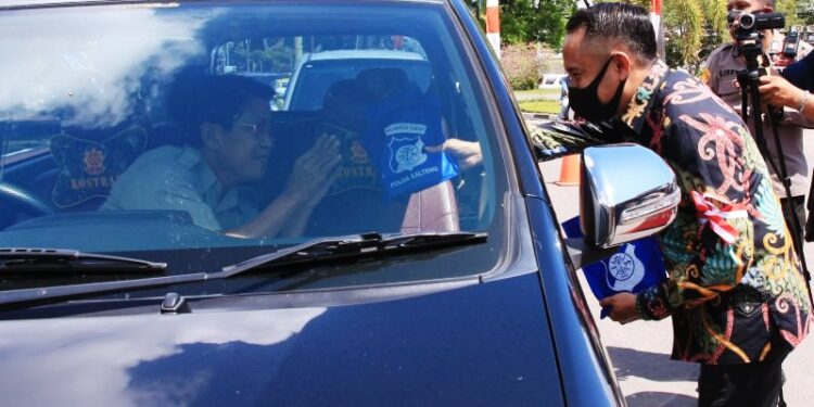 Wali Kota Palangka Raya, Fairid Naparin (kanan) saat membagikan maker kepada pengguna jalan di kawasan Bundaran Besar Palangka Raya, Kamis (10/8/2020). ANTARA/Rendhik Andika