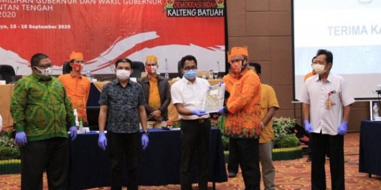 Ketua KPU Provinsi Kalteng Harmain Ibrohim (berbaju jingga) saat menyerahkan hasil rekapitulasi DPS Pilgub Kalteng kepada tim paslon peserta pilkada di Palangka Raya, Rabu (16-9-2020). (ANT)