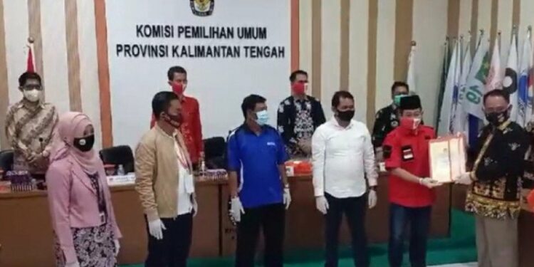 Ketua KPU Kalteng, Harmain Ibrohim (berbaju hitam) saat menyerahkan dokumen kepada tim penghubung pasangan bakal calon gubernur-wakil gubernur di Palangka Raya, Minggu (13/9/2020). (ANT/MIN3)