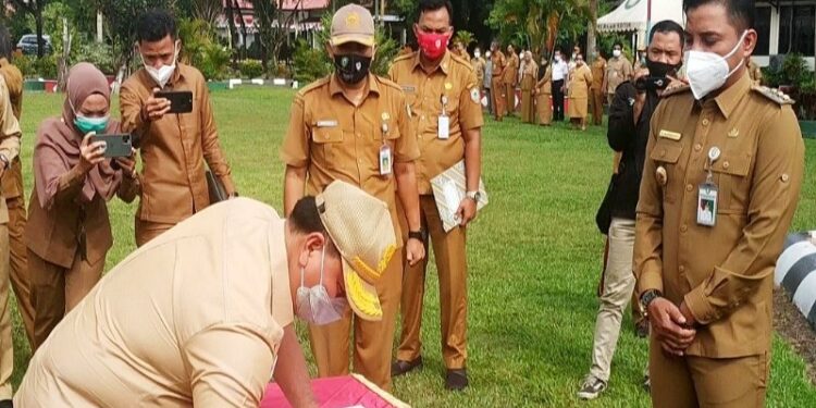 Halikinnor menandatangani berita acara pengembalian semua aset dinas yang digunakannya setelah kini mundur dari jabatan Sekretaris Daerah Kotawaringin Timur, disaksikan Bupati Supian Hadi, Selasa (22/9/2020). (ANT)