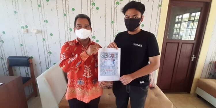 Kepala SMAN 1 Kurun Batuah (kiri) dan Fajri Yanoor menunjukkan desain poster yang berhasil menjadi juara 1 FLS2N tingkat Provinsi Kalteng, di Kuala Kurun, Kamis (24/9/2020). (ANTARA/Chandra)