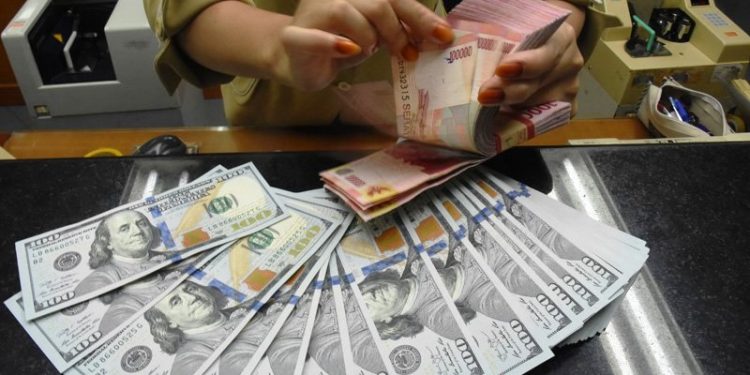 Petugas kasir menghitung mata uang rupiah di gerai penukaran mata uang asing Ayu Masagung, Kwitang, Jakarta Pusat. (ANTARA FOTO/Indrianto Eko Suwarso)