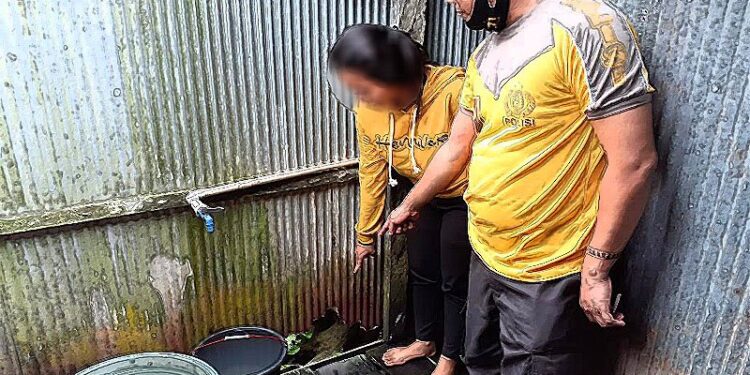MR (16) didampingi anggota Polsek Dusun Tengah menunjukan lobang pada papan kayu kamar mandinya, di rumahnya di Kecamatan Dusun Tengah, Kamis (10/9). Lobang tersebut diduga digunakan KT (29) dalam kasus pelecehan seksual yang saat ini ditangani Polsek Dusun Tengah. ANTARA/HO Polsek Dusun Tengah