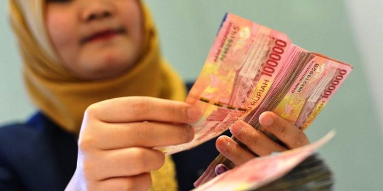 Petugas teller menghitung pecahan uang rupiah di Kantor Pusat Bank Mandiri, Kamis (28/6/2018). (ANTARA FOTO/Wahyu Putro A)