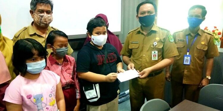 Kepala Dinas Pendidikan Kabupaten Kapuas, Suwarno Muriyat menyerahkan bantuan untuk pelajar yang mengikuti Kompetisi Sains Nasional (KSN) Sekolah Dasar tingkat Provinsi Kalimantan Tengah. (ANT/IST)
