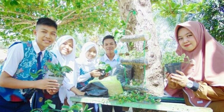 Atika Widyastuti Basri bersama anak didik pelajar SMPN 4 Muara Teweh di Desa Lemo II, Kecamatan Teweh Tengah, sebelum pandemi COVID-19. (ANT/IST)