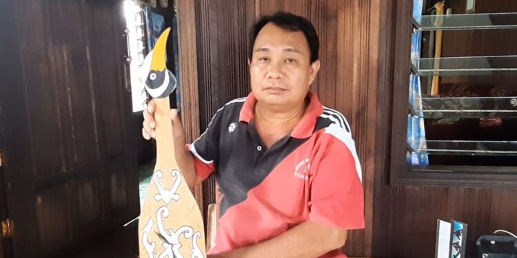 Ketua Komunitas Kacapi Tingang Harmuda menunjukkan jam dengan desain kacapi yang ada di kediamannya, di Kelurahan Tampang Tumbang Anjir, Kecamatan Kurun, Sabtu (3/10/2020).