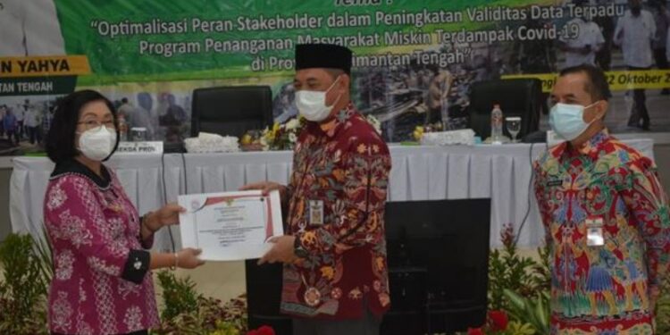 Sekda Kalteng Fahrizal Fitri (tengah) didampingi Kepala Bappedalitbang Kalteng menyerahkan penghargaan sebagai Juara 1 atas Penilaian Kinerja Penanganan Stunting untuk Aksi 1 sampai Aksi 4 tahun pertama kepada Wabup Gumas Efrensia L.P. Umbing (kiri), di Palangka Raya, Kamis (22/10/2020). (ANTARA/HO – Setda Kalteng)