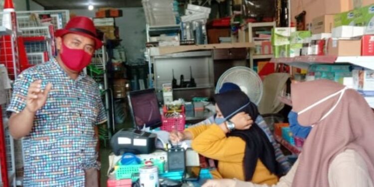Ketua Pasar Besar Palangka Raya Hamidan (kiri) saat memberikan sosialisasi kepada para pedagang tentang bahaya COVID-19 dan pencegahannya hingga penerapan protokol kesehatan di Pasar Besar Palangka Raya. (ANT/IST)