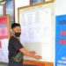 Pegawai KPU Gumas menempel pengumuman pendaftaran anggota KPPS di papan informasi kantor KPU setempat, Kamis (30/9/2020). (Foto : KPU Gumas)