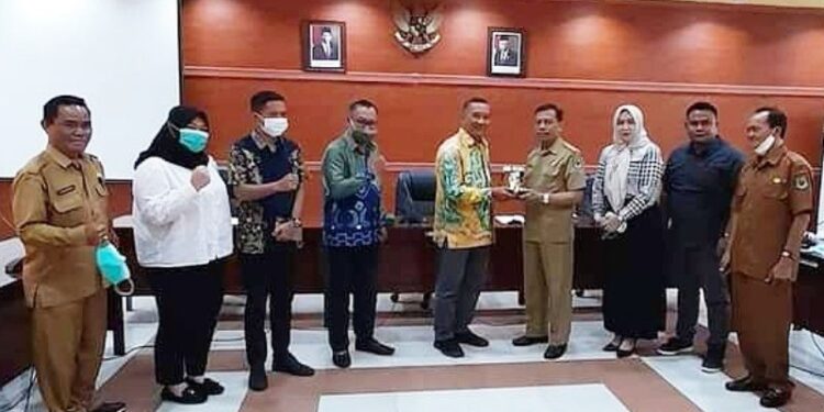 Kepala Sub Bagian Umum Sekretariat DPRD Kabupaten Kapuas, Ajeng, menerima cendramata dari Ketua Komisi I DPRD Kabupaten Tapin, Muhctar, usai kunjungan di DPRD setempat, Selasa (6/10/2020). (ANT)