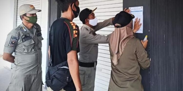Petugas Satpol PP Kabupaten Kapuas, membagikan selebaran pemberitahuan tentang Peraturan Bupati Kapuas Nomor 46 tahun 2020, kepada masyarakat setempat, Rabu (7/10/2020). (ANT/IST)