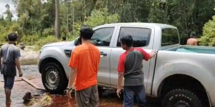 Warga berjibaku menaikan kendaraan roda empat yang amblas saat melalui jalan penghubung di dua desa Kecamatan Mantangai, Kabupaten Kapuas, Selasa (20/10/2020) lalu. (ANT/IST)