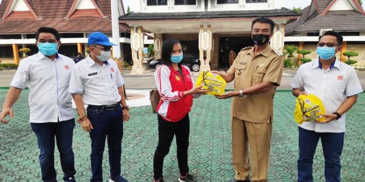 Wakil Bupati Barito Utara Sugianto Panala Putra didampingi Ketua KONI setempat H El Ronny dan Sekretaris Simamoraturahman menyerahkan secara simbolis APD dan kelengkapan lainnya kepada perwakilan atlet di halaman kantor bupati setempat di Muara Teweh,Senin (5/10/2020). (ANT/IST)
