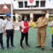 Wakil Bupati Barito Utara Sugianto Panala Putra didampingi Ketua KONI setempat H El Ronny dan Sekretaris Simamoraturahman menyerahkan secara simbolis APD dan kelengkapan lainnya kepada perwakilan atlet di halaman kantor bupati setempat di Muara Teweh,Senin (5/10/2020). (ANT/IST)