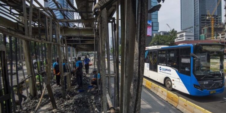 Sejumlah petugas membersihkan puing Halte Bus Trans-Jakarta Tosari yang hangus saat kericuhan unjuk rasa menolak pengesahan Undang-Undang Cipta Kerja di Jalan MH. Thamrin, Jakarta, Jumat (9/10/2020). Sejumlah fasilitas umum rusak dalam kericuhan yang terjadi Kamis (8/10). (ANT)