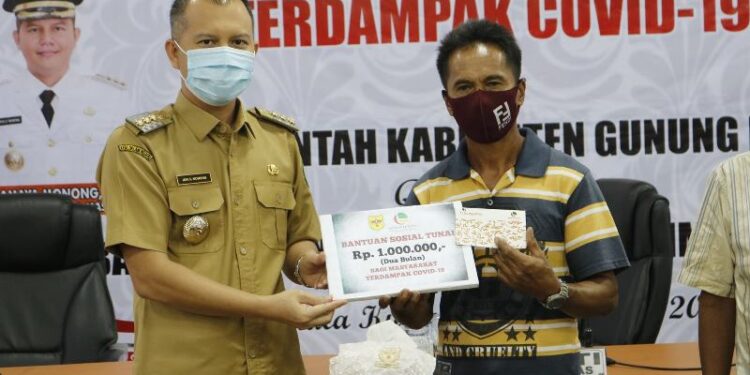 Bupati Gumas Jaya S Monong (kiri) menyalurkan BST dari APBD kabupaten secara simbolis kepada KPM, di Kuala Kurun, Selasa (10/11/2020). (Foto : Protokol dan Perjalanan Setda Gumas)
