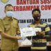 Bupati Gumas Jaya S Monong (kiri) menyalurkan BST dari APBD kabupaten secara simbolis kepada KPM, di Kuala Kurun, Selasa (10/11/2020). (Foto : Protokol dan Perjalanan Setda Gumas)