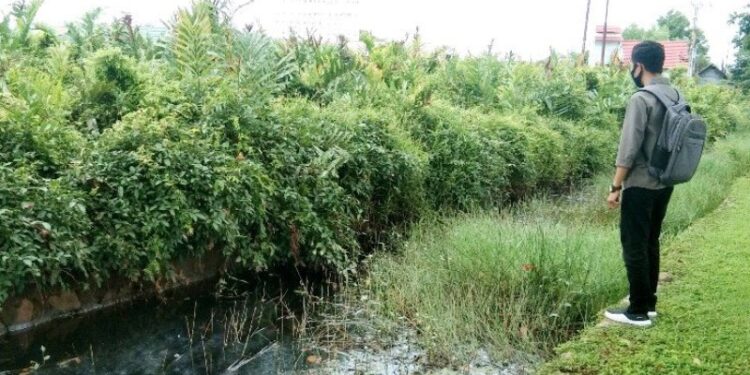 Seorang warga berada di sekitar drainase Jalan A Yani Kuala Pembuang, Senin, (2/11/2020). (ANT)