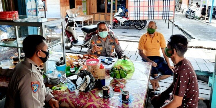 Kapolsek Pahandut Kota Palangka Raya, Kompol Edia Sutaata (dua dari kiri) bersama anggotanya dan warga di Jalan Kalimantan, berdiskusi dan menyampaikan ajakan penerapan protokol kesehatan serta mewujudkan pilkada damai, Senin, (2/11/2020). (ANT/IST)