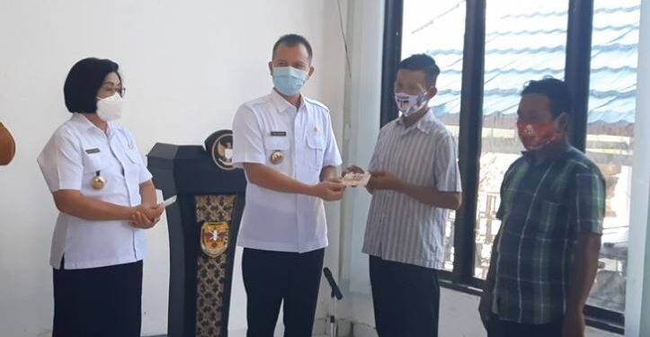 Bupati Gumas Jaya Samaya Monong didampingi Wabup Efrensia L.P. Umbing menyerahkan kartu tani secara simbolis kepada sejumlah petani, di Kuala Kurun, Rabu (11/11/2020). (ANT)