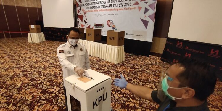 Ketua KPU Kalteng, Harmain Ibrohim (kiri) saat simulasi pemungutan suara berprotokol kesehatan COVID-19 di Kota Palangka Raya, Senin (2/11/2020). (ANT)