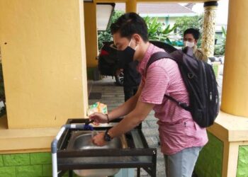 Ketika hendak bertamu, salah satu warga diwajibkan mencuci tangan di depan kantor DPRD Bartim di Tamiang Layang, Senin (26/10) lalu. (ANT)