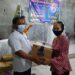 Penatua di Majelis Jemaat GKE Tuyun, Radius Prakarsa (kiri) menyerahkan bingkisan kasih secara simbolis kepada jemaat, usai pelaksanaan ibadah malam Natal di Gereja Efrata GKE Tuyun, Kamis (24/12/2020).