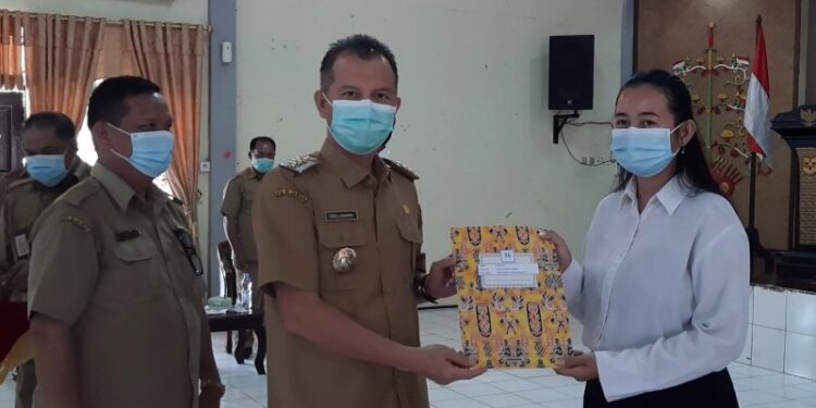 Bupati Gumas Jaya S Monong didampingi Kepala BKPSDM Gumas Guanhin menyerahkan petikan SK CPNS 2019 di lingkup pemkab itu kepada seorang perwakilan CPNS, di Kuala Kurun, Senin (14/12/2020). (ANT)