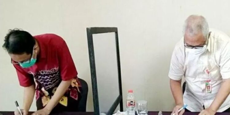 Kepala Dinas Sosial Bartim, Riza Rahmadi (kanan) menandatangani hasil rapat rekonsiliasi data kepesertaan penduduk yang didaftarkan pemerintah setempat pada Program Jaminan Kesehatan Nasional di Muara Teweh, Selasa, (22/12/2020). (ANT/IST)