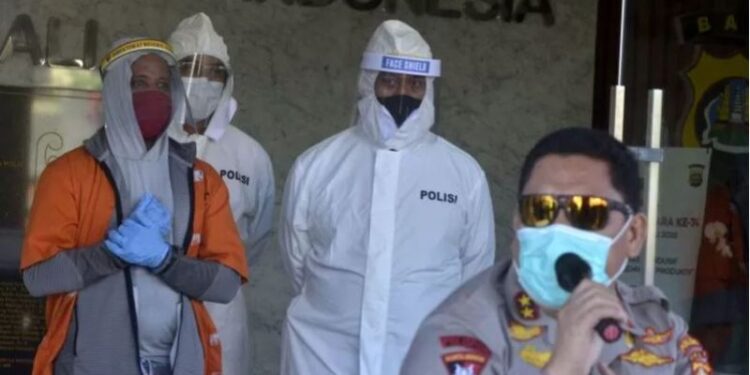 Kapolda Bali Irjen Pol Petrus Reinhard Golose (kanan) menunjukkan warga negara Amerika Serikat berinisial BM (kiri) yang merupakan subjek 'Red Notice' buronan Interpol saat rilis di Mapolda Bali, Bali, Jumat (24/7/2020). (ANT)