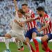 Pemain Real Madrid Luka Modric diapit dua pemain Atletico Madrid pada pertandingan Liga Spanyol di stadion Santiago Bernabeu, Madrid, Sabtu (1/2/2020). Real Madrid memenangi partai derby tersebut dengan skor 1-0. (ANT FOTO/REUTERS/Susana Vera/pras)