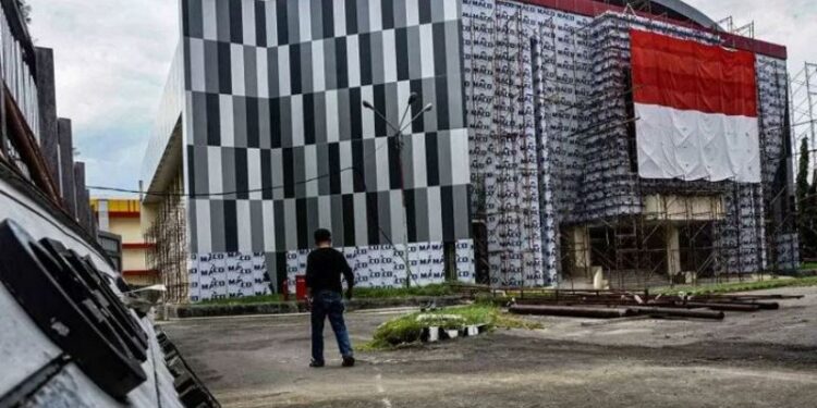 Warga melintas dekat Gedung Olahraga (GOR) Cenderawasih di Kota Jayapura, Papua, Selasa (22/9/2020). Renovasi gedung tersebuti masuk tahap akhir dan ditargetkan selesai di penghujung tahun 2020 untuk dipergunakan sebagai Venue Tinju pada PON XX tahun 2021 mendatang. (ANT)