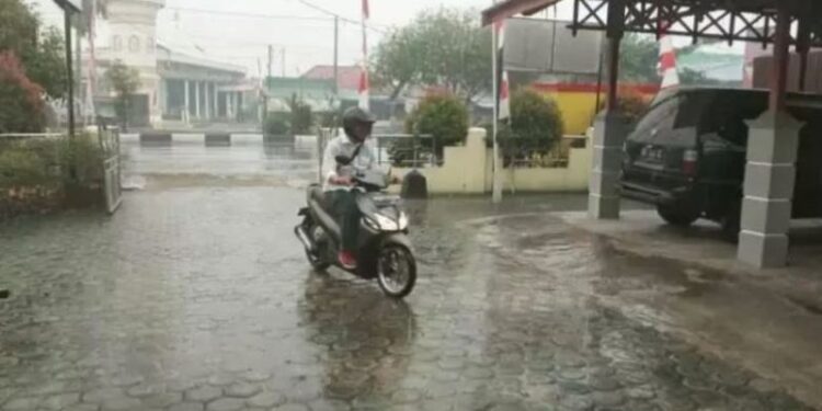 Ilustrasi - Salah satu warga berkendara saat hujan mengguyur wilayah Kota Palangka Raya, Rabu (14/8/2019). (ANT)