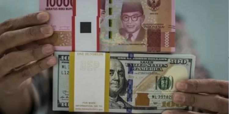 Karyawan menunjukkan uang rupiah dan dolar AS di Kantor Cabang Plaza Mandiri, Jakarta. ANTARA FOTO/Aprillio Akbar/wsj.