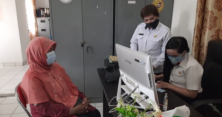Kabid Kelembagaan, Pemberdayaan dan Pengawasan Koperasi dan UKM pada Distransnakerkop dan UKM Gumas Margaretha (berdiri) dan pegawai Distransnakerkop dan UKM Gumas membantu memeriksa status penerima bantuan salah satu pelaku usaha yang datang ke kantor dinas setempat, Rabu (2 Desember 2020). (ANT)