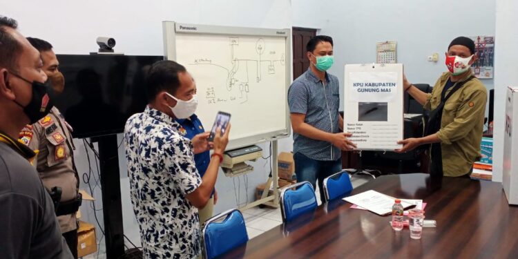 Ketua KPU Gumas Stepenson disaksikan Ketua Bawaslu Gumas Walman Tristianto, Kabagops Polres Gumas AKP Aries Nugroho, Kasat Intelkam Polres Gumas AKP Tri Prasetyo, dan lainnya saat menyerahkan dokumen hasil pleno kepada KPU Kalteng, di Palangka Raya, Selasa (15/12/2020). (Foto : Polres Gumas)