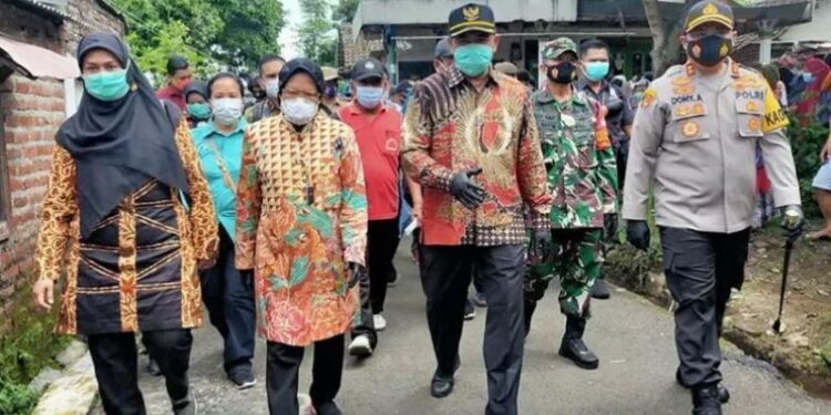Menteri sosial Tri Rismaharini didampingi Bupati Mojokerto Pungkasiadi (kedua kanan) dan Kapolres Mojokerto AKBP Donny Alexander melakukan kunjungan ke Sumberglagah, Kota Mojokerto, Jawa Timur, Sabtu (2/1/2021). (ANT)