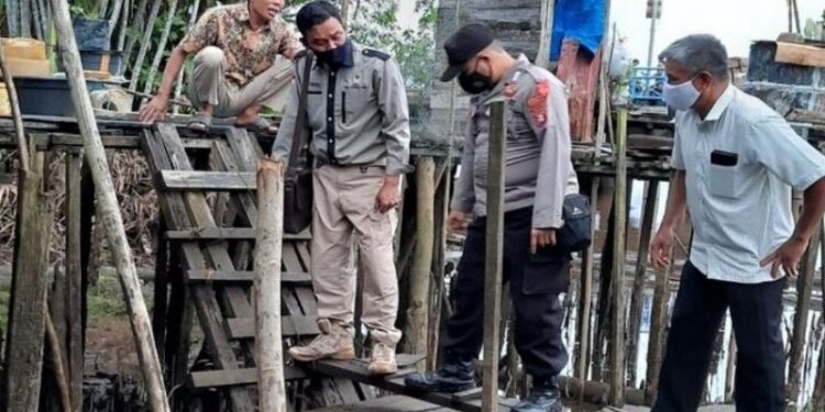 Komandan Jaga BKSDA Kalteng Pos Sampit, Muriansyah bersama polisi dan keluarga korban memeriksa lokasi kejadian serangan buaya di Desa Pelangsian Kecamatan Mentawa Baru Ketapang, Sabtu (2/1/2021). (ANT/IST)