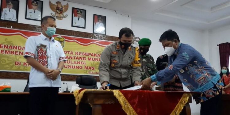 Kapolres Gumas AKBP Rudi Asriman, Bupati Jaya S Monong, dan Pabung Kodim 1016/Plk Kapten Inf M Ayyub, bersama Sekda Yansiterson, melakukan penandatanganan nota kesepakatan tentang Pembentukan Desa Pantang Mundur atau Lewu Isen Mulang, di Ruang Rapat Lantai I, Kamis (11/2/2021). (Foto : MN)