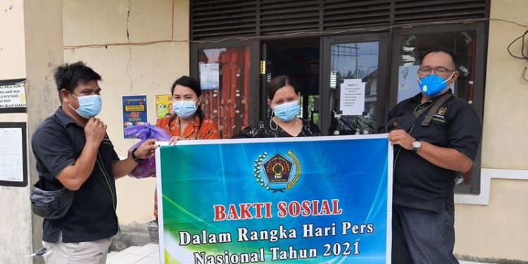 Ketua PWI Kabupaten Gumas Poppy Oktovery (kanan) menyerahkan paket sembako kepada Sekretaris Lurah Tampang Tumbang Anjir Septinawati (kanan kedua) untuk disalurkan kembali kepada warga kurang mampu di kelurahan itu, Kamis (18/2/2021). (ANT)