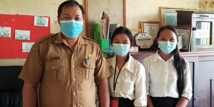 Lurah Tampang Tumbang Anjir Berjoaldi (kiri) berfoto bersama siswi SMKN 1 Kurun yang sedang menjalani prakerin di kantor kelurahan setempat, Senin (15/2/2021). (ANTARA)