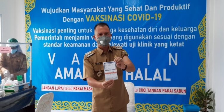 Bupati Gumas Jaya S Monong menunjukkan surat keterangan telah divaksin COVID-19, di Puskesmas Tampang Tumbang Anjir, Kecamatan Kurun, Senin (1/2/2021).