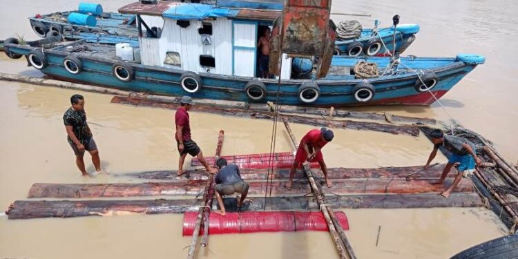 Karyawan PT HPL sedang mengenjot perakitan log pond di Kelurahan Kampuri, Kecamatan Mihing Raya dengan melalui jalur sungai.