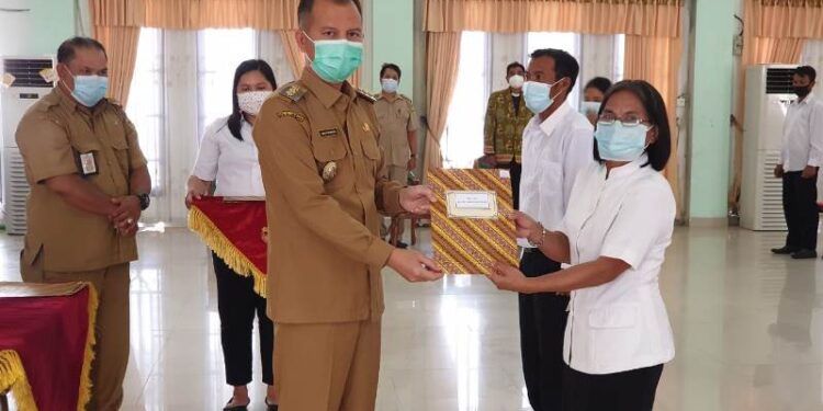Bupati Gumas Jaya S Monong menyerahkan SK pengangkatan PPPK secara simbolis kepada salah seorang perwakilan PPPK. Penyerahan SK pengangkatan PPPK dilakukan di GPU Damang Batu Kuala Kurun, Selasa (6/4/2021). (Foto : Protokol dan Perjalanan Setda Gumas)