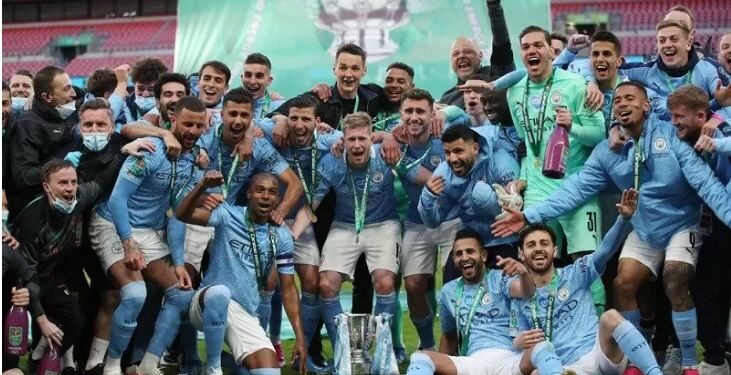 Para pemain dan staf Manchester City berpose bersama trofi Piala Liga Inggris setelah mereka memenangi kompetisi musim 2020/21 dengan mengalahkan Tottenham Hotspur dalam partai final di Stadion Wembley, London, Inggris, Minggu (25/4/2021) waktu setempat. (ANT/IST)